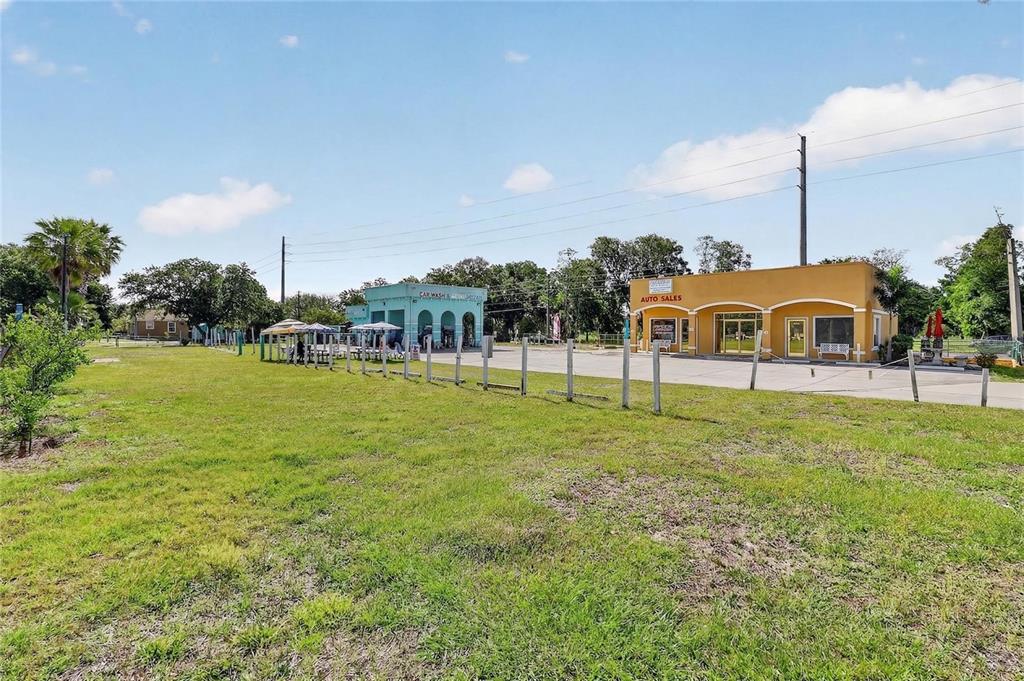 A grassy lot sits in front of a car wash and an auto sales building — 0 9TH STREET, WINTER GARDEN, FL