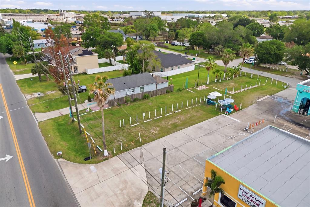 An aerial view shows a vacant grassy lot situated between a hair salon and a house — 0 9TH STREET, WINTER GARDEN, FL