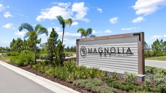 A sign for Magnolia Bay stands in a landscaped area with palm trees and sky — 289 HOLLY BANK AVENUE, NOKOMIS, FL
