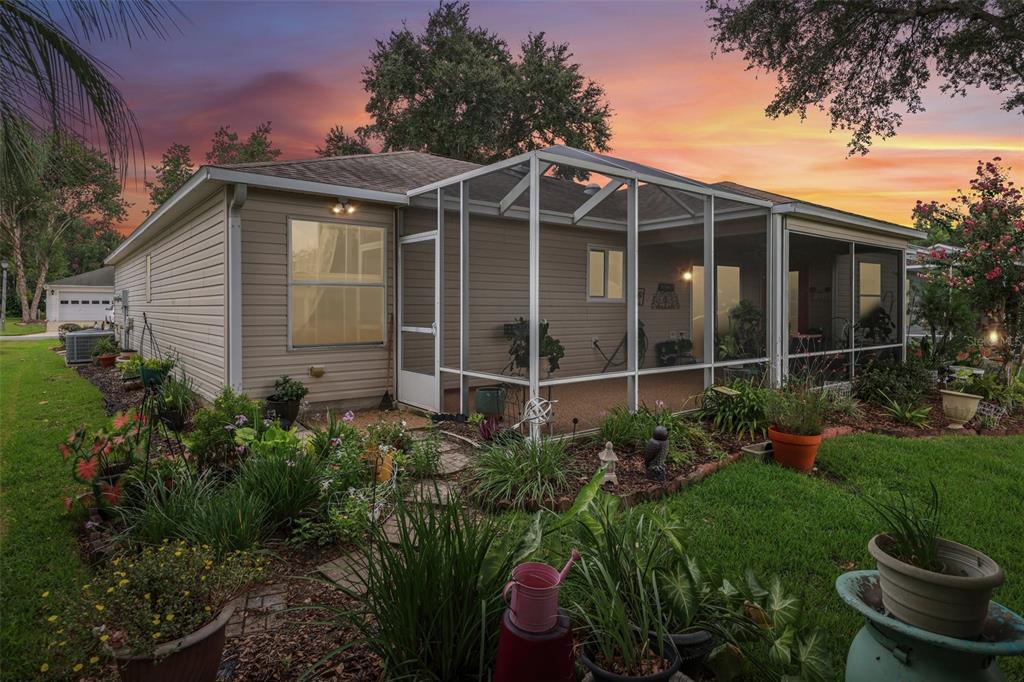 A single-story house with beige siding, a white garage door, and a painted concrete driveway — 3495 AUBURNDALE AVENUE, THE VILLAGES, FL