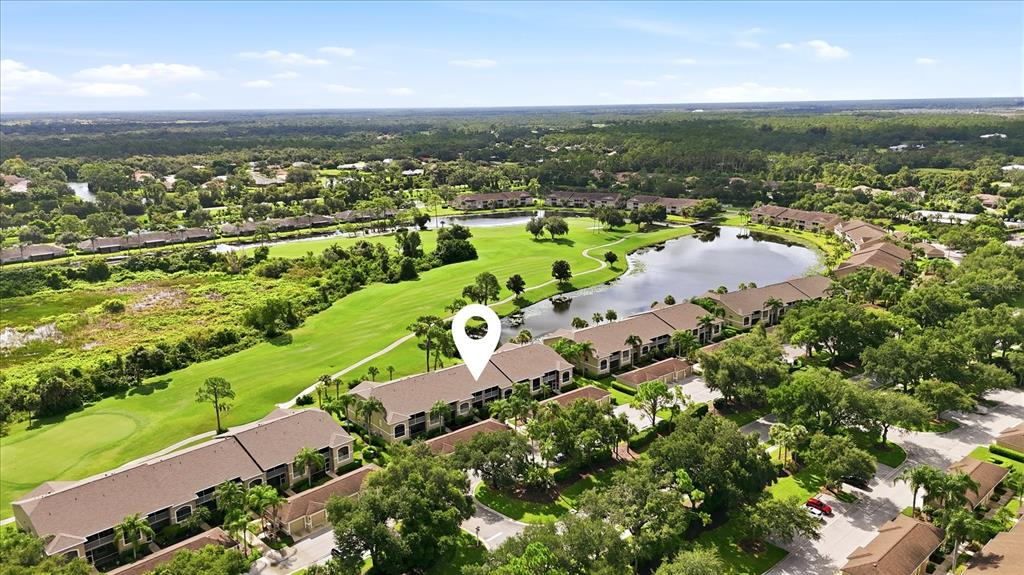 An aerial view shows multi-story apartment buildings situated next to a golf course and lake — 5221 MAHOGANY RUN AVENUE UNIT 224, SARASOTA, FL