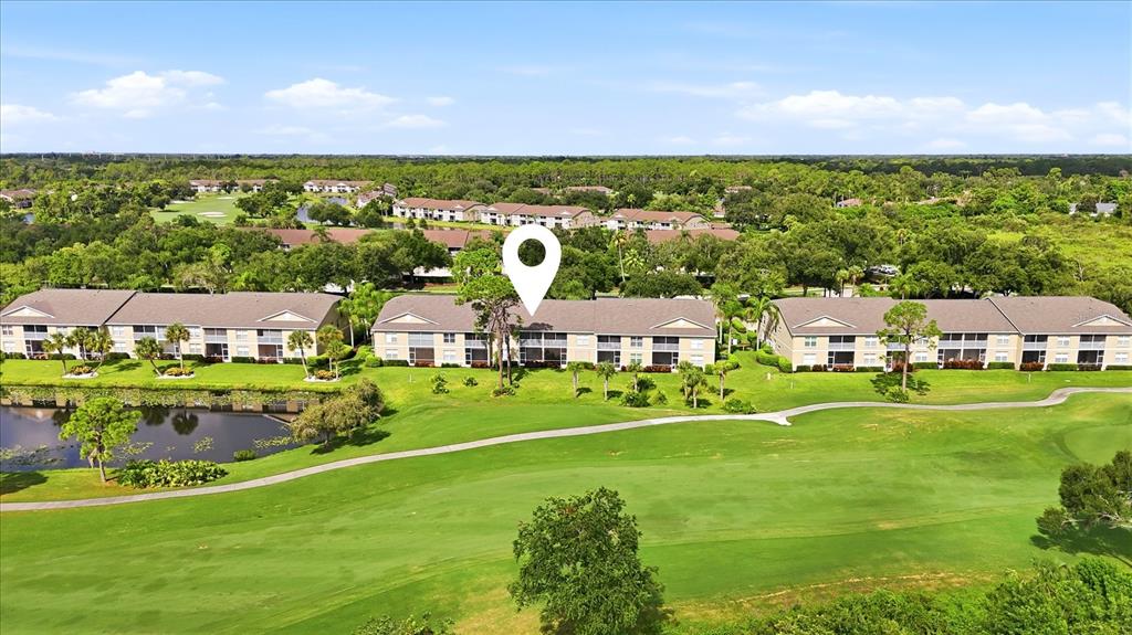 An aerial view shows multi-story residential buildings situated along a golf course and pond — 5221 MAHOGANY RUN AVENUE UNIT 224, SARASOTA, FL
