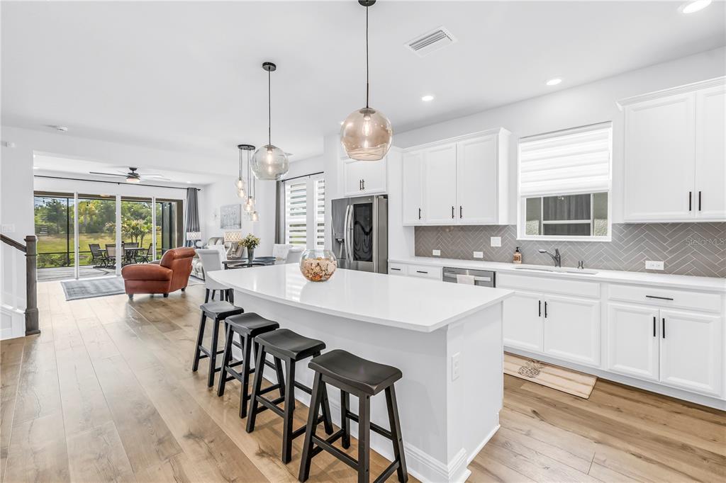 A home office features blue built-in cabinetry, open shelving, a wooden desk, and wood flooring — 8217 TRIMBELLE, PARRISH, FL