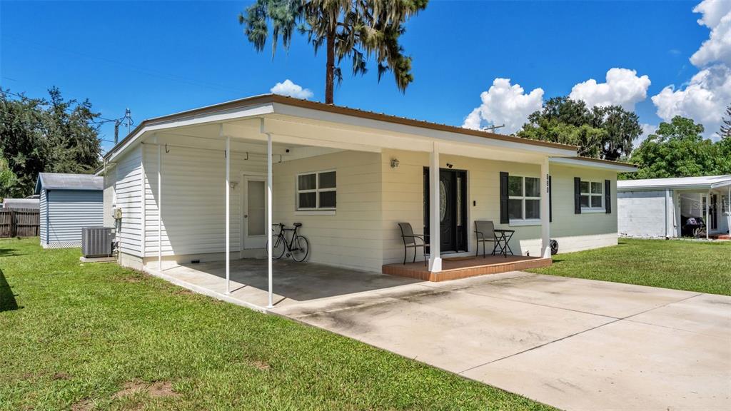 A single-story house with a carport, concrete driveway, and a small front porch — 680 SUNSET DRIVE, BARTOW, FL