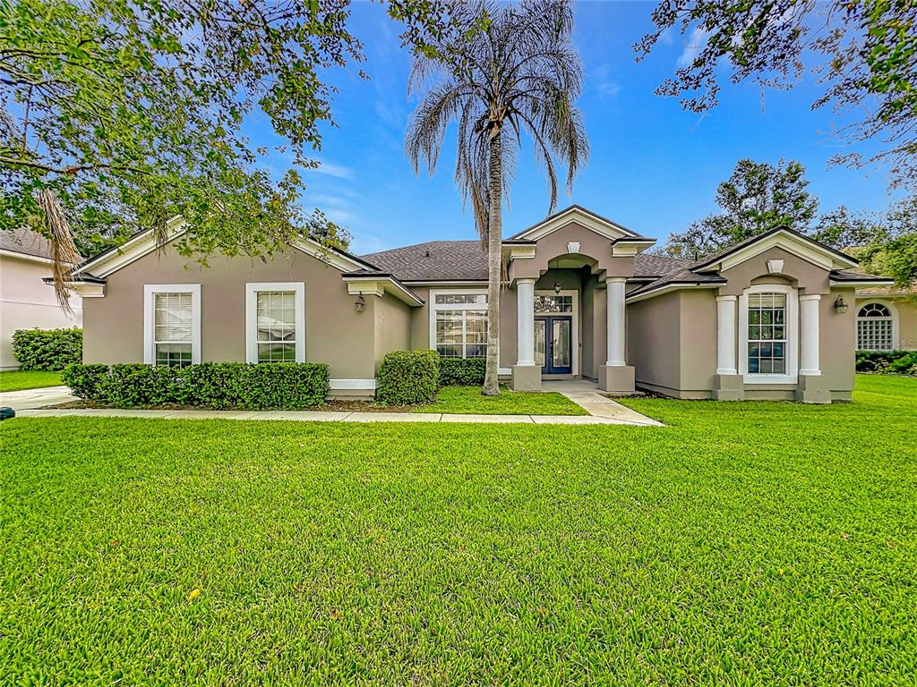 A single-story house with a tan exterior, a palm tree, and a green lawn — 420 TWIN OAKS LANE, ST JOHNS, FL