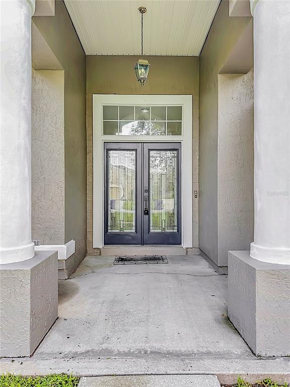 A covered entryway features a double front door with decorative glass and a hanging lantern — 420 TWIN OAKS LANE, ST JOHNS, FL