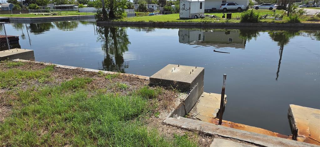 A concrete bulkhead and dock foundation sit along a canal in a residential area — 13320 CAROL DRIVE, HUDSON, FL
