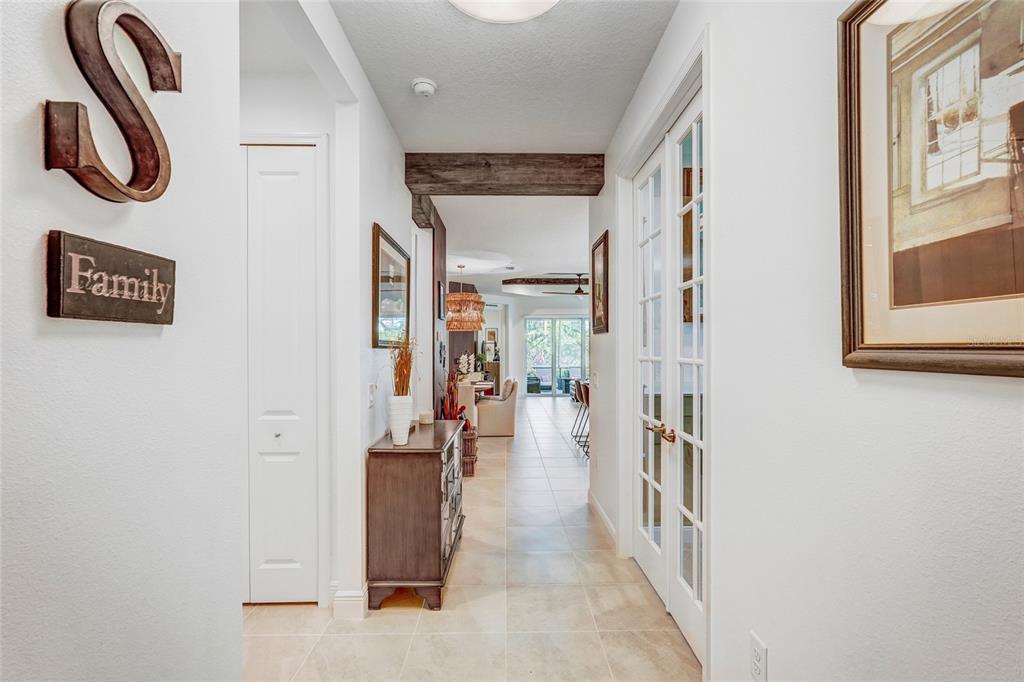 A built-in home bar features wooden shelves, a slatted accent wall, and hanging glassware — 10233 LAKE WALES CIRCLE, SARASOTA, FL