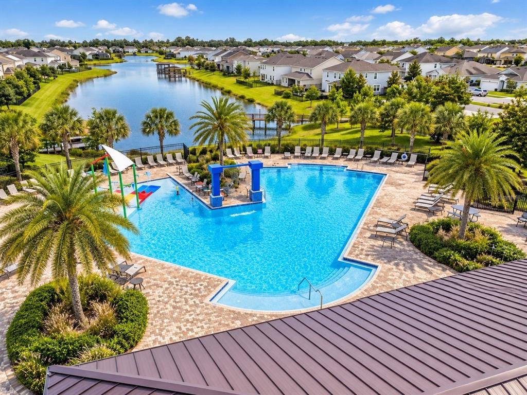 An elevated view of a community swimming pool surrounded by palm trees and houses — 2695 NOTTEL DRIVE, ST CLOUD, FL