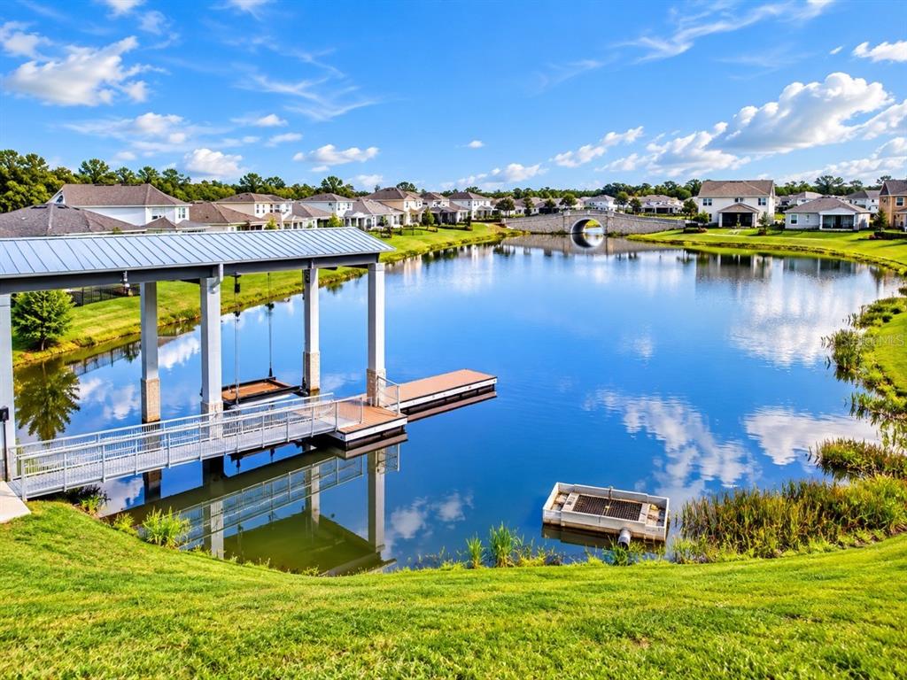 An aerial view shows a boat dock and pier extending into a pond near houses — 2695 NOTTEL DRIVE, ST CLOUD, FL