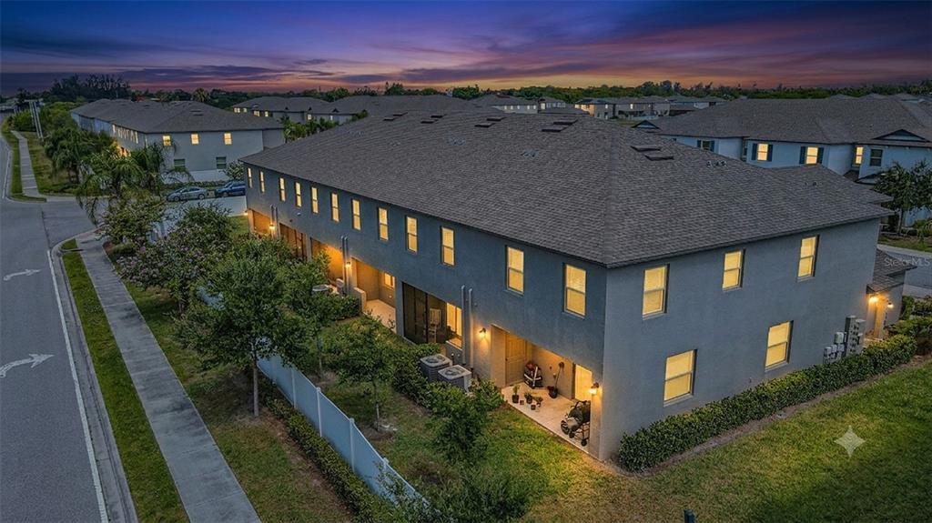 An aerial view of a multi-unit townhouse building at dusk with a small backyard — 817 ROYAL EMPRESS DRIVE, RUSKIN, FL