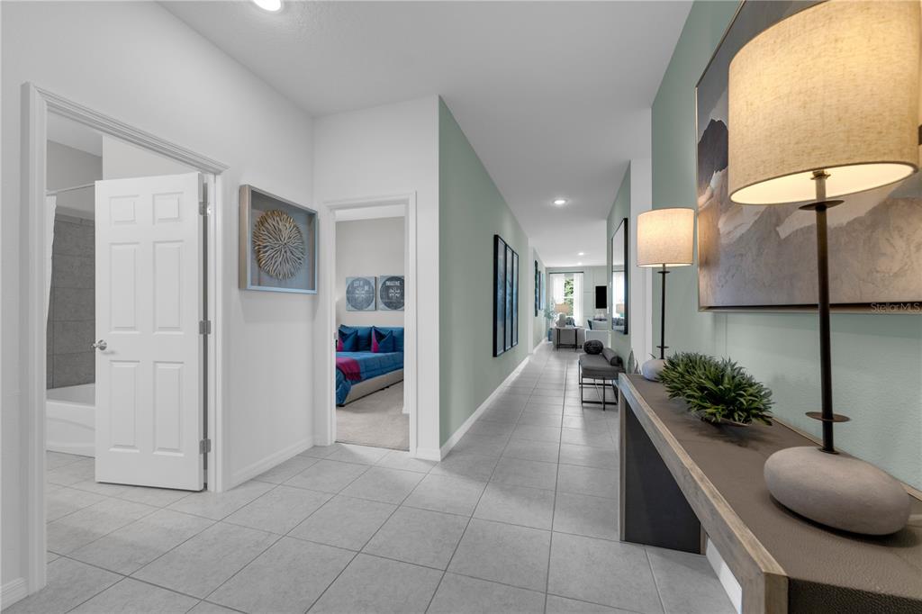 A tiled hallway features a console table with lamps, a bathroom, and a bedroom entrance — 6739 WINTERBERRY DRIVE, LAKE HAMILTON, FL