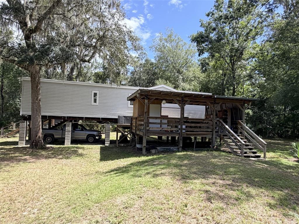 A kitchen features white cabinets, stainless steel appliances, a farmhouse sink, and wood-look flooring — 1957 SE 477 AVENUE, OLD TOWN, FL