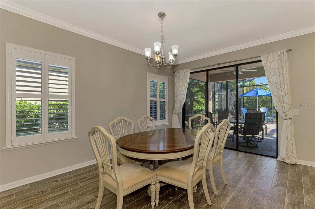 A dining room features a wooden table, six chairs, a chandelier, and sliding glass doors — 2148 LA PALMA AVENUE, PORT CHARLOTTE, FL