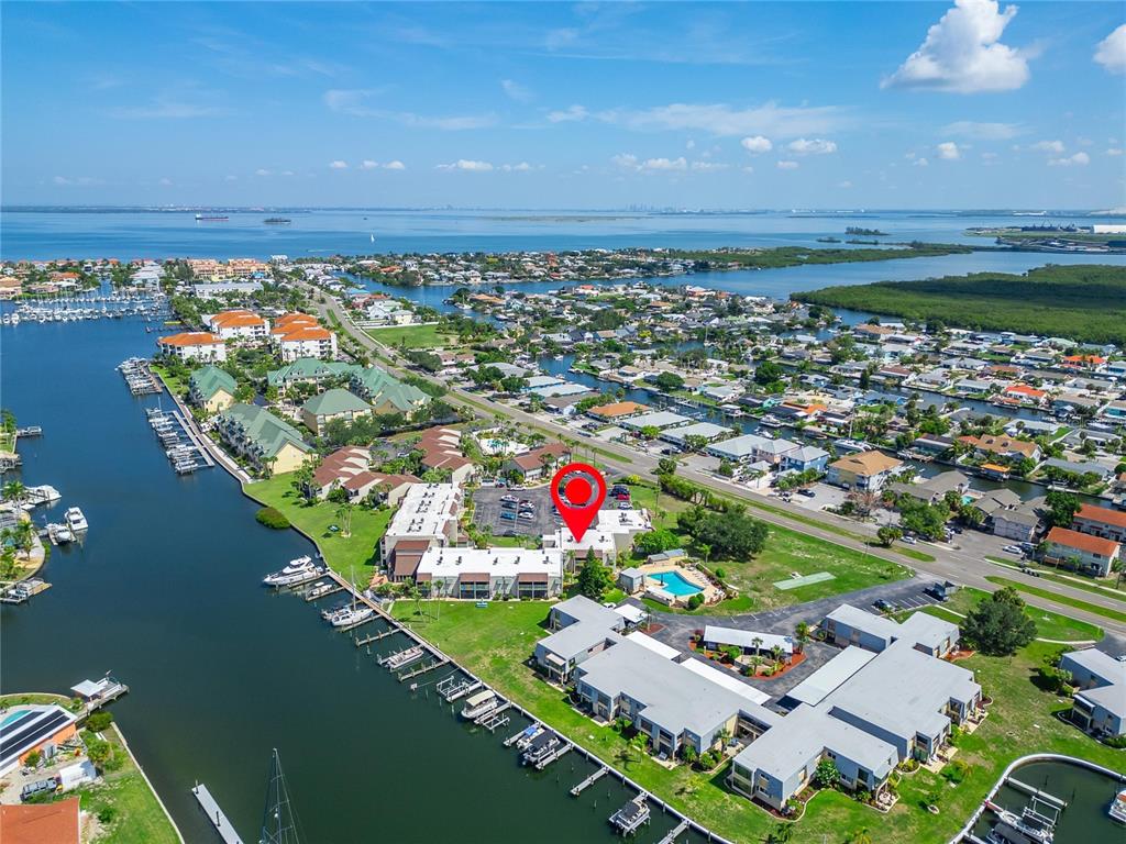 An aerial view shows a waterfront residential complex with boat slips and a swimming pool — 1028 APOLLO BEACH BOULEVARD UNIT 104, APOLLO BEACH, FL