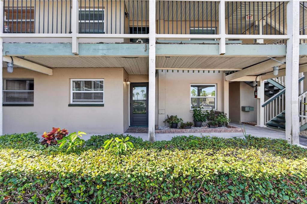 A ground-level apartment entrance features a dark door, windows, and a covered patio area — 1028 APOLLO BEACH BOULEVARD UNIT 104, APOLLO BEACH, FL