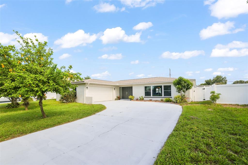 A single-story house with a white brick exterior, a two-car garage, and a concrete driveway — 13635 97TH TERRACE, SEMINOLE, FL