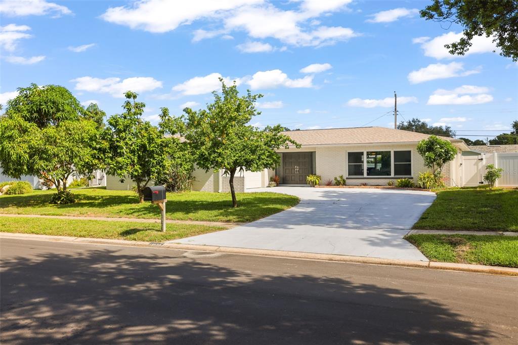 A single-story house with a white brick exterior, a concrete driveway, and a front lawn — 13635 97TH TERRACE, SEMINOLE, FL