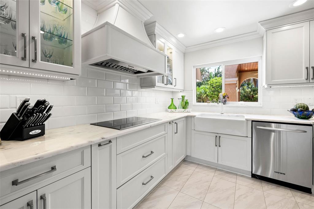 A furnished outdoor patio features a stone floor, seating area, and lush tropical landscaping — 1124 SEVILLE LANE NE, ST PETERSBURG, FL