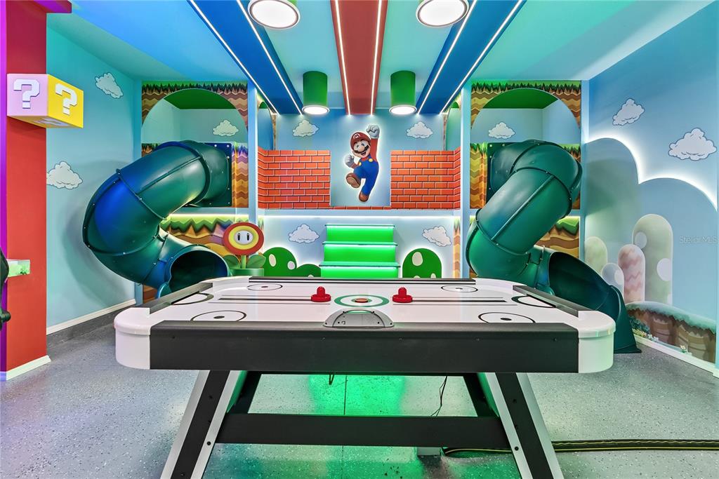 A Super Mario-themed game room features an air hockey table, two slides, and wall murals — 15961 CAPE CORAL LOOP, CLERMONT, FL