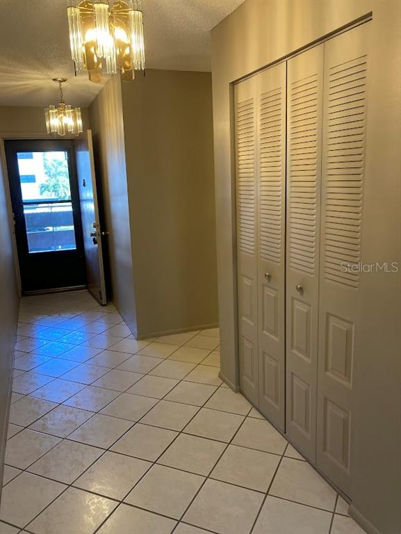 An entryway features tiled floors, a louvered closet, and two hanging light fixtures — 5980 80TH STREET N UNIT 205, ST PETERSBURG, FL