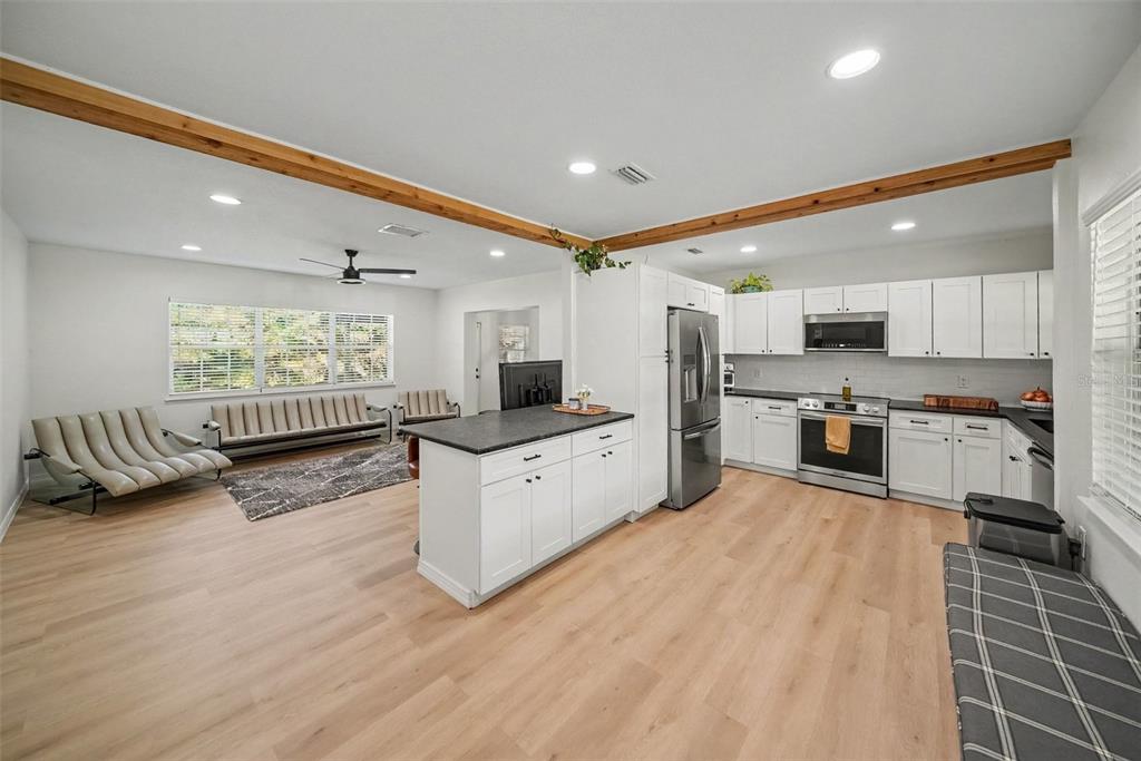 A covered front porch features a gray door, rocking chairs, and a patterned outdoor rug — 4636 W BAY COURT AVENUE, TAMPA, FL