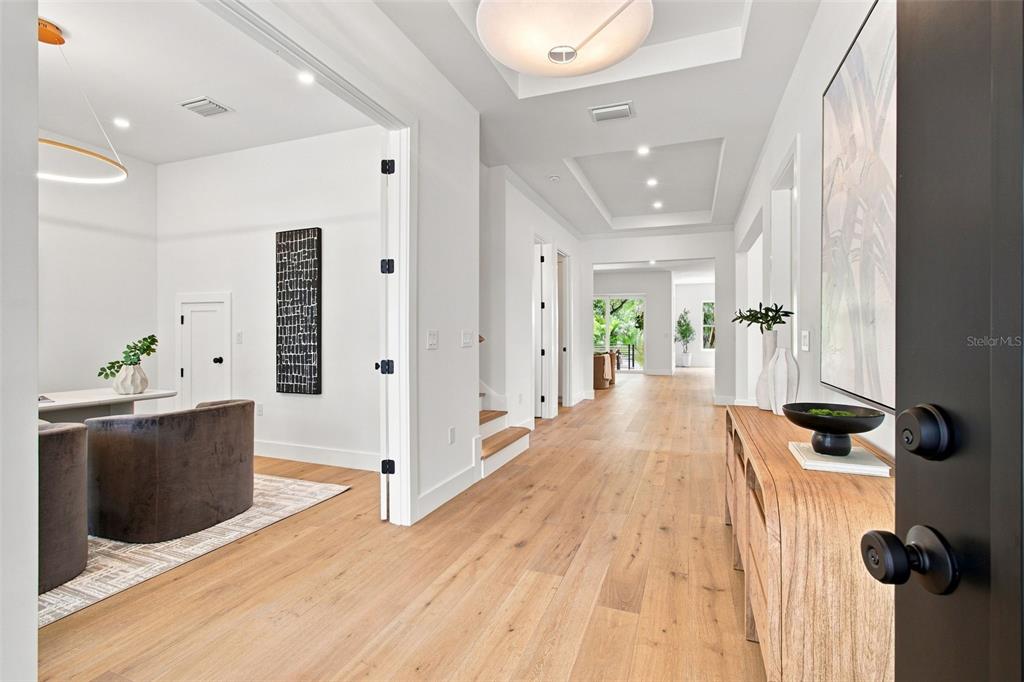 A bright entryway features light wood flooring, a tray ceiling, and an adjacent home office — 3609 S GARDENIA AVENUE, TAMPA, FL