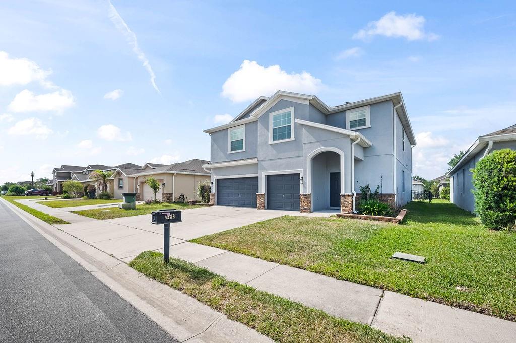 A two-story suburban house with a gray exterior, two garage doors, and a front lawn — 4538 CORTLAND DRIVE, DAVENPORT, FL