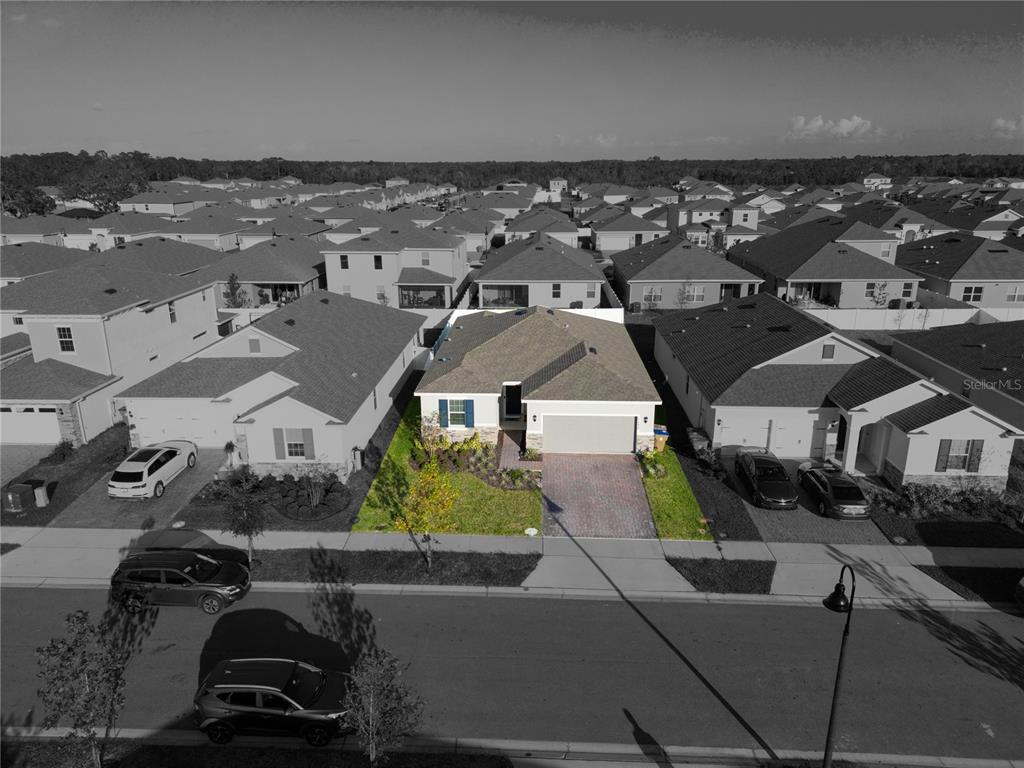 An aerial view shows a single-story suburban house with a paved driveway and green lawn — 1177 FOX HEDGE LANE, ST CLOUD, FL