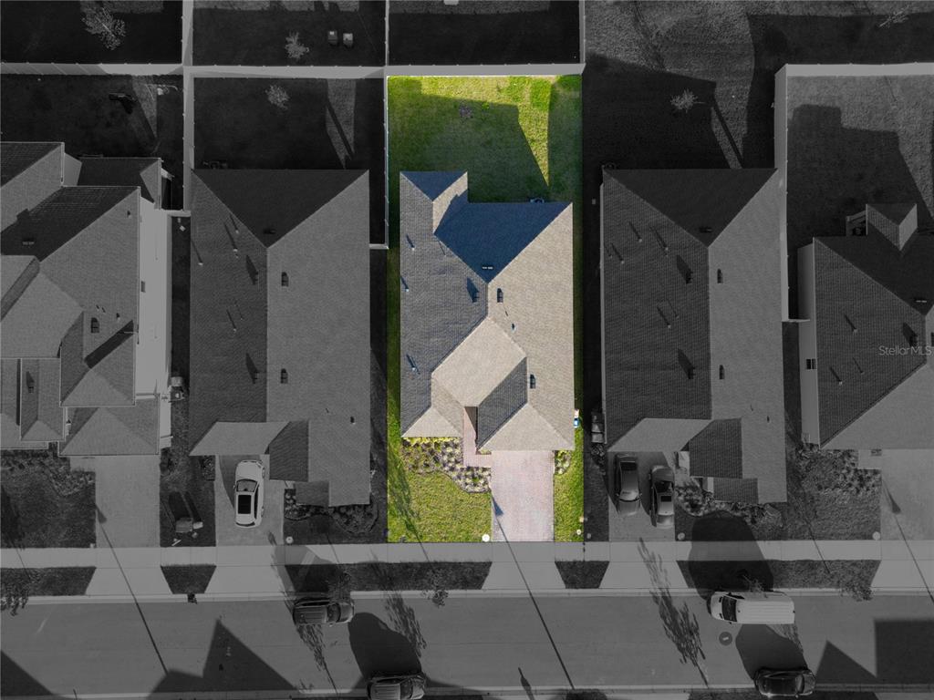 An aerial view shows a single-family house with a gray roof and a backyard — 1177 FOX HEDGE LANE, ST CLOUD, FL