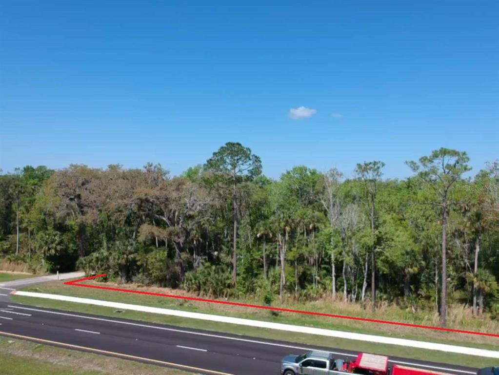 A red line outlines a wooded lot adjacent to a paved road and sidewalk — W INDIAN RIVER BOULEVARD, EDGEWATER, FL