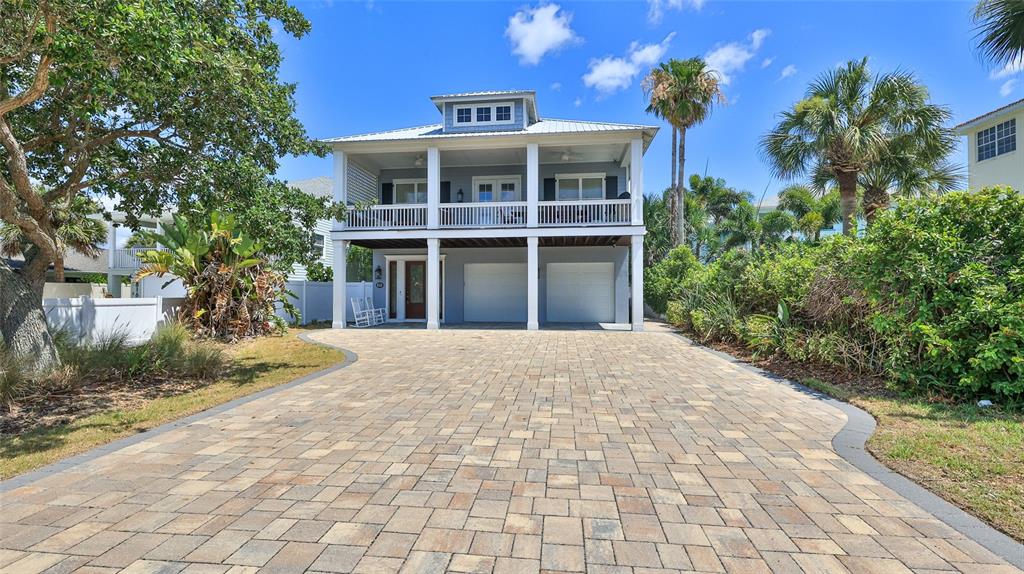A two-story house with a paved driveway, a covered porch, and a metal roof — 818 OCEAN AVENUE, NEW SMYRNA BEACH, FL
