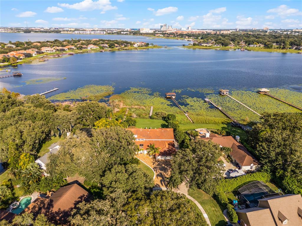 A two-story house with a tiled roof, a large paved driveway, and palm trees — 8605 BAY SHORE COVE, ORLANDO, FL