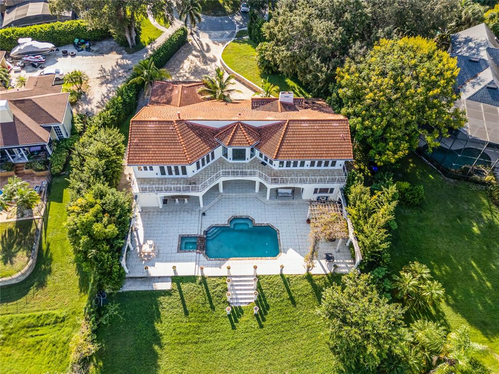 A two-story house with a white exterior, a swimming pool, and a covered patio area — 8605 BAY SHORE COVE, ORLANDO, FL