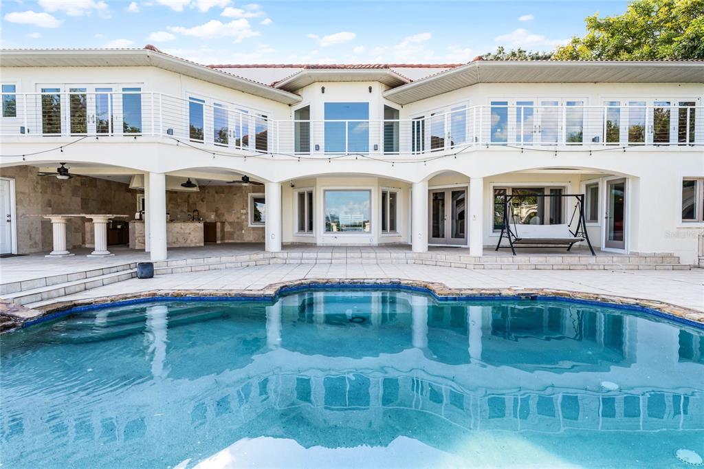 A two-story house with a tiled roof, stone retaining wall, and paved driveway — 8605 BAY SHORE COVE, ORLANDO, FL
