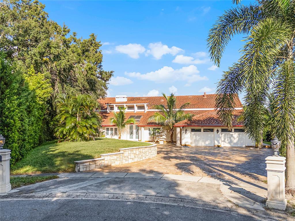 An aerial view of a two-story house with a tiled roof, pool, and large backyard — 8605 BAY SHORE COVE, ORLANDO, FL