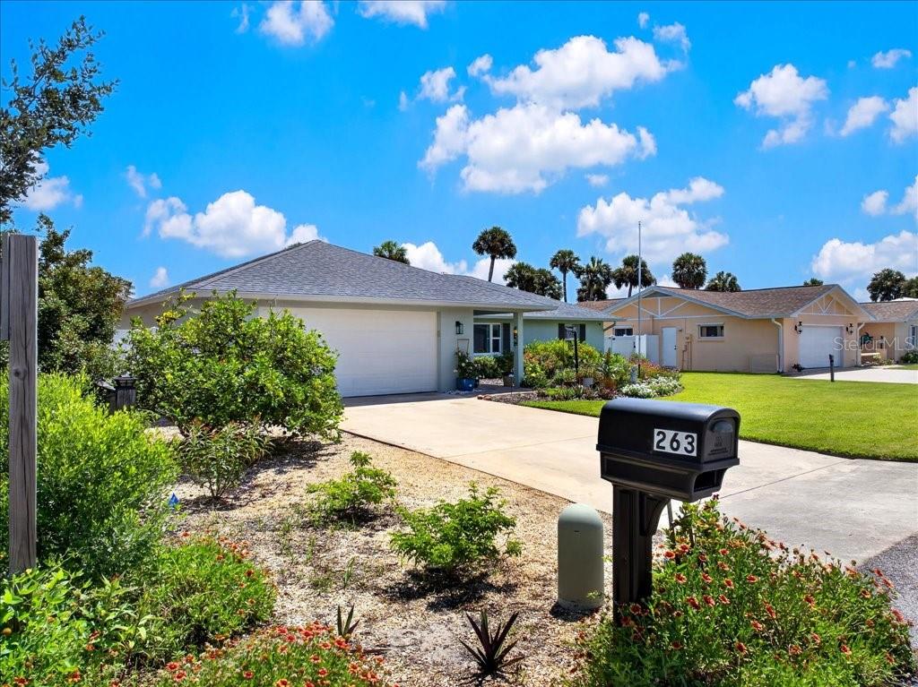 A single-story house with a two-car garage and a mailbox in the foreground — 263 OCEAN PALM DRIVE, FLAGLER BEACH, FL