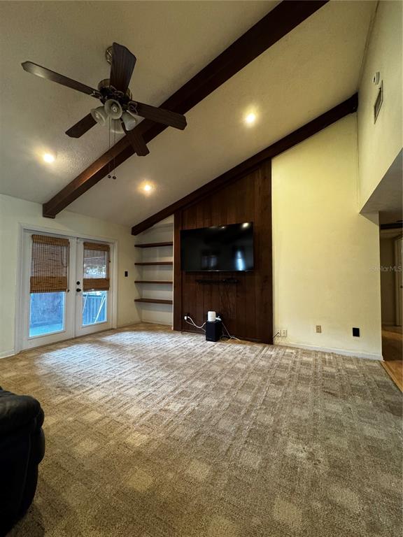 A living room features vaulted ceilings with exposed wood beams, a television, and bar seating — 118 EUCLID LOOP, SEFFNER, FL