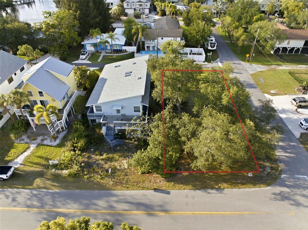 An aerial view shows a vacant, tree-covered lot outlined in red next to two houses — 0 GEORGIA AVE. AVENUE, CRYSTAL BEACH, FL