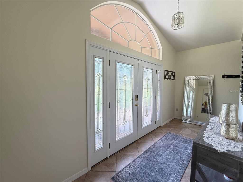 An entryway features a double front door with glass inserts, a transom window, and tile flooring — 7613 NW 46TH STREET, OCALA, FL