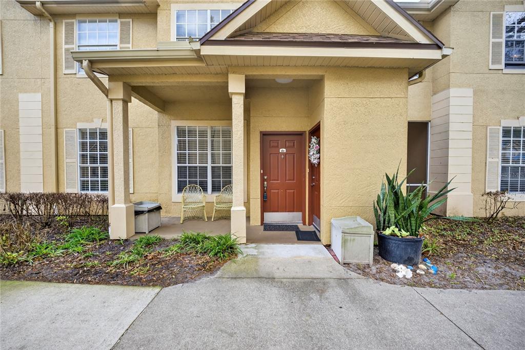 A beige two-story townhouse exterior features a covered entryway with two brown front doors — 839 GRAND REGENCY POINT UNIT 104, ALTAMONTE SPRINGS, FL
