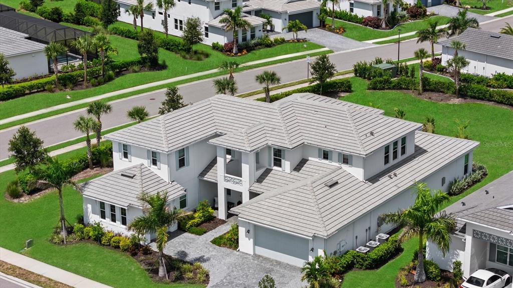 An aerial view of a two-story white house with a gray tile roof and driveway — 8129 NEVIS RUN, LAKEWOOD RANCH, FL