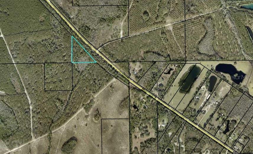 This is an aerial map showing a triangular parcel of land highlighted in blue — 1925 CR-13, BUNNELL, FL