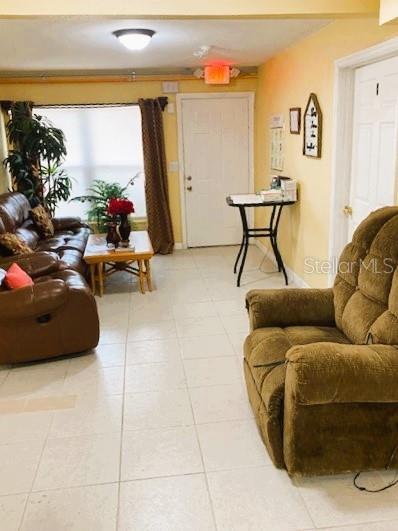 A living room features a brown leather sofa, a brown recliner, and a small side table — 130 W 7TH STREET, CHULUOTA, FL