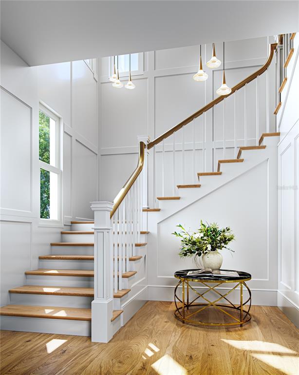 This is a rendering of a foyer featuring a wooden staircase and a round accent table — 303 MORNINGSIDE DRIVE, PALM HARBOR, FL