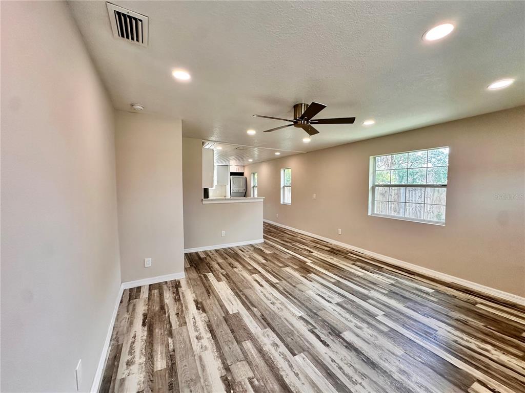 A gray house with a blue front door and a gravel driveway — 8517 N HIGHLAND AVENUE, TAMPA, FL