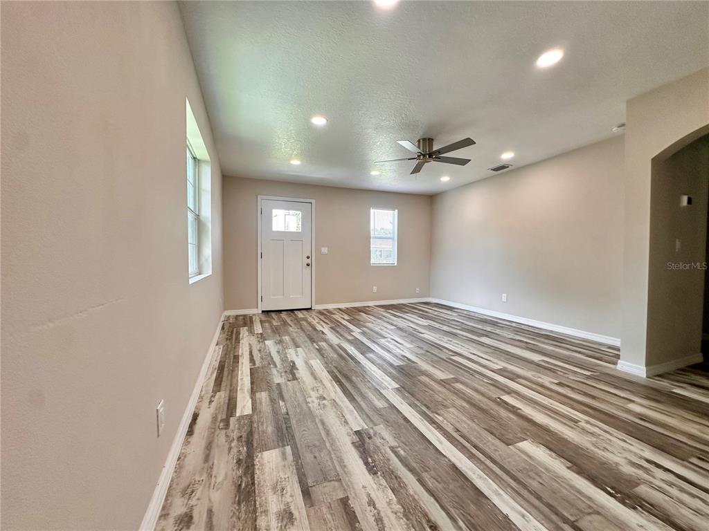 A small, light-gray shed with two windows sits in a large, gravel-covered backyard — 8517 N HIGHLAND AVENUE, TAMPA, FL