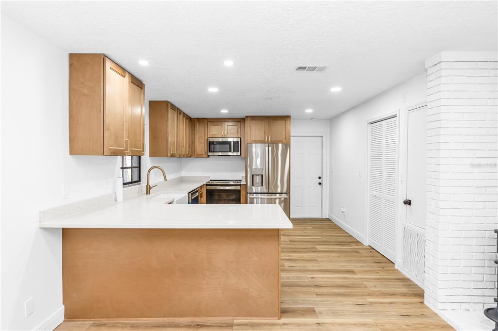 A single-story house with a white brick exterior, a blue front door, and a garage — 6800 ACKERMAN AVENUE, COCOA, FL