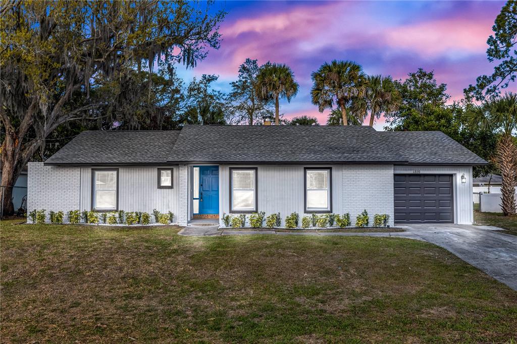 A kitchen with wood cabinets, stainless steel appliances, white countertops, and light wood flooring — 6800 ACKERMAN AVENUE, COCOA, FL