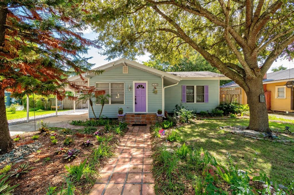 A light blue house with a purple front door and a brick walkway in the yard — 1919 S PALMETTO AVENUE, SANFORD, FL